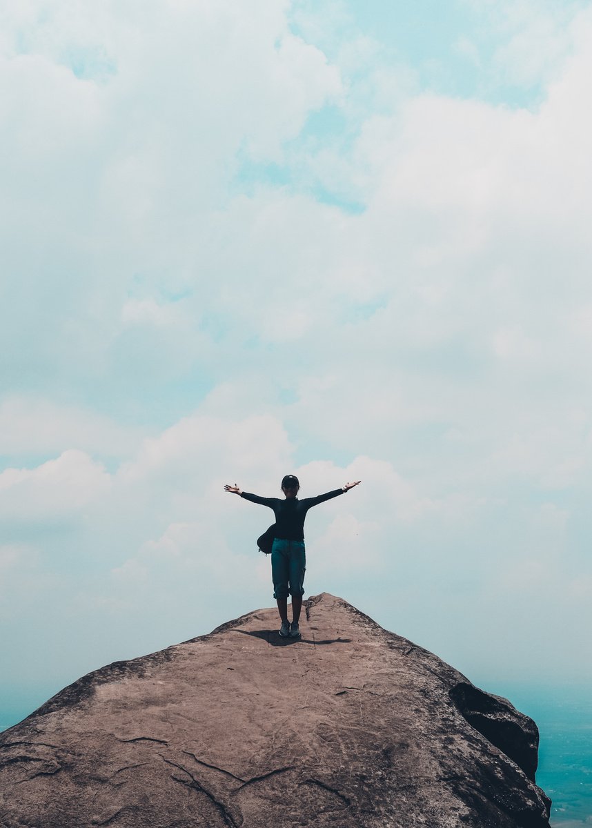 Woman Standing on Top of a Mountain and Spreading Her Arms 